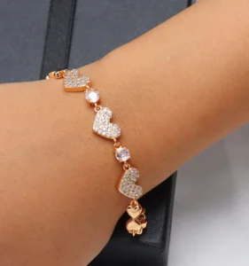 Gold-toned bracelet with heart-shaped links adorned with sparkling zircon stones.