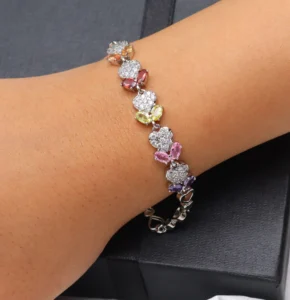 Silver-toned bracelet with sparkling zircon stones and pastel floral gemstone accents.