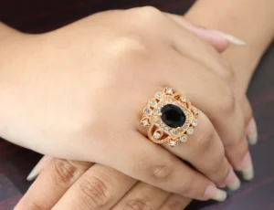 Square gold-toned ring with black zircon center and clear zircon accents.