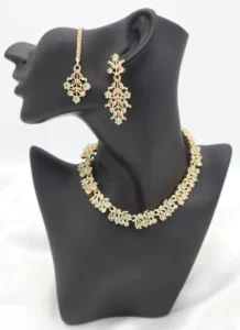 Green gemstone floral necklace set with matching earrings and maang tikka in premium stainless steel.