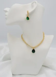 Golden floral necklace with green pear-shaped pendant and matching drop earrings, crafted in stainless steel for an elegant look.