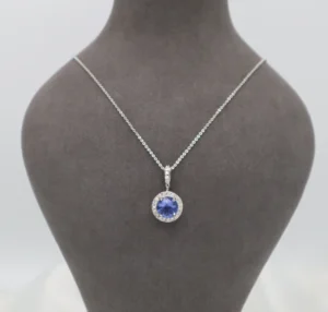 Silver-toned pendant featuring a round-cut dark blue stone on a delicate chain.